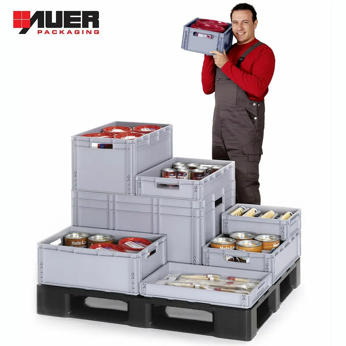 Auf einer Palette stehen 7 Euroboxen von AUER unterschiedlicher Größe, gefüllt mit Konservendosen. Dahinter ein Arbeiter mit einer weiteren Eurobox in der Hand